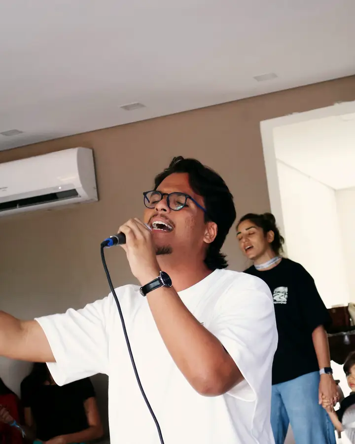 Jovem conduzindo o louvor ao microfone